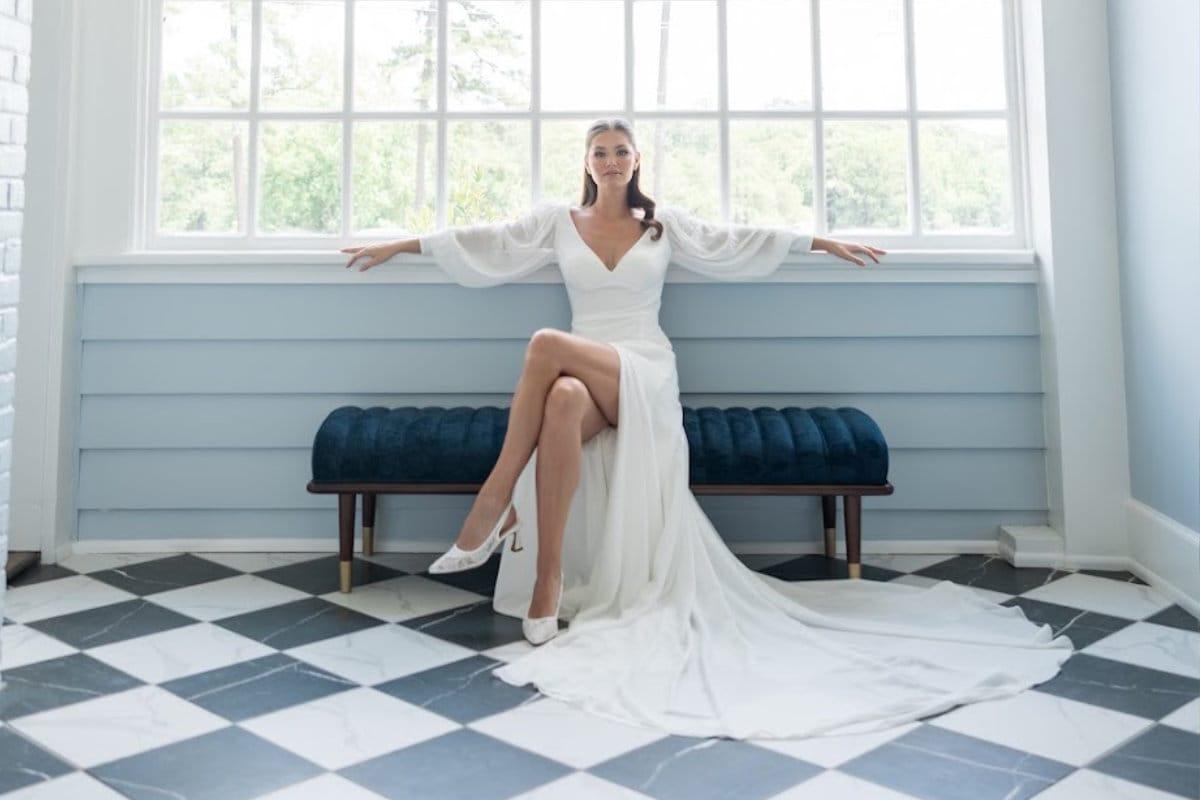 Bride sitting on blue chair in front of large window